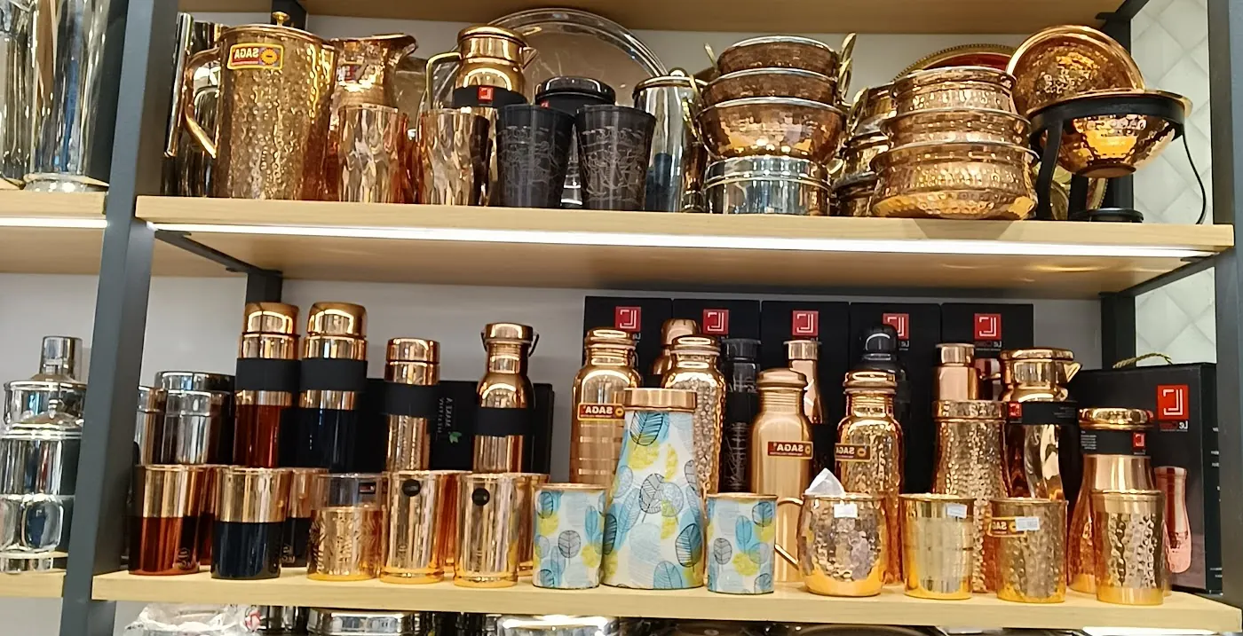A shelf of copper bottles, jugs and hammered copper bowls in the shop